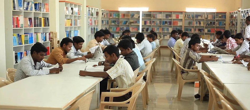 Students reading at long tables in the library