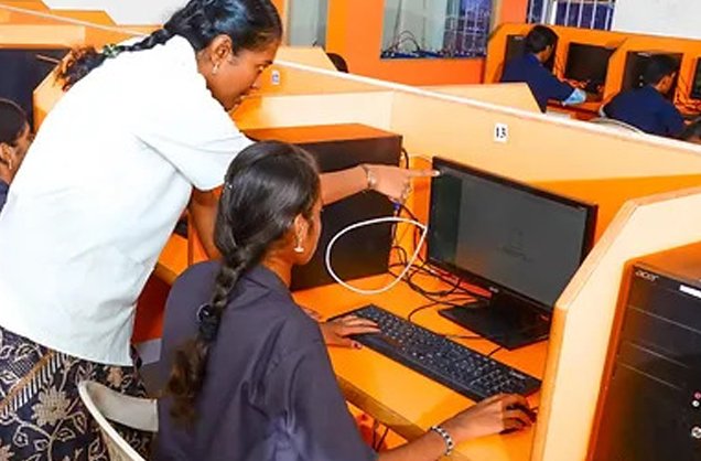Staff member helping a student in the computer lab